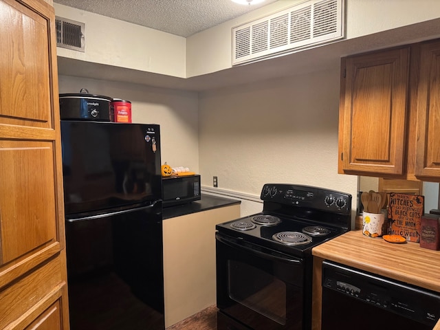 kitchen with a textured ceiling, black appliances, visible vents, and brown cabinets