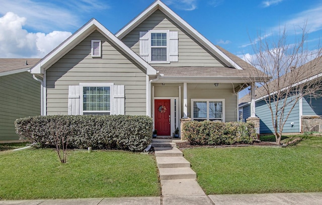 bungalow-style house featuring roof with shingles and a front yard