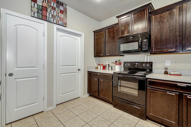 kitchen featuring dark brown cabinetry, black appliances, light countertops, and light tile patterned flooring