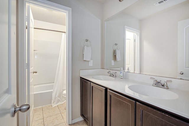 bathroom with tile patterned floors, visible vents, double vanity, and a sink