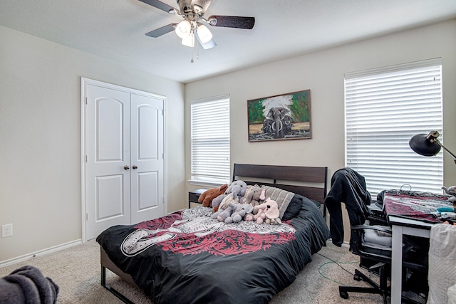 carpeted bedroom with a closet, baseboards, and ceiling fan