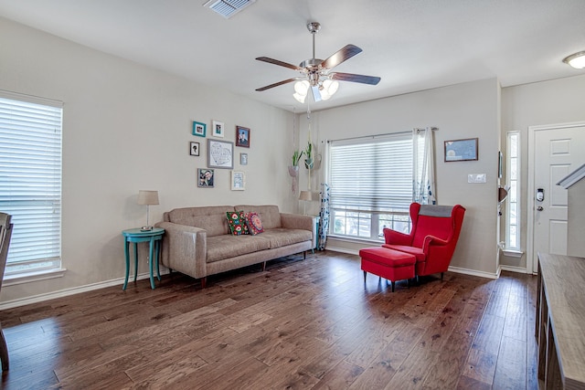 living area featuring visible vents, baseboards, ceiling fan, and wood finished floors