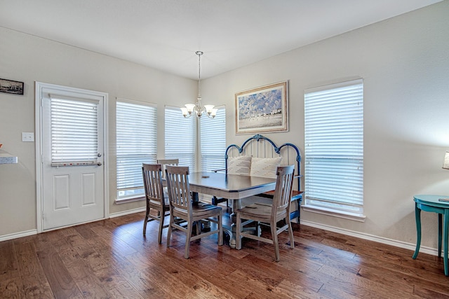 dining room with a notable chandelier, baseboards, and wood finished floors