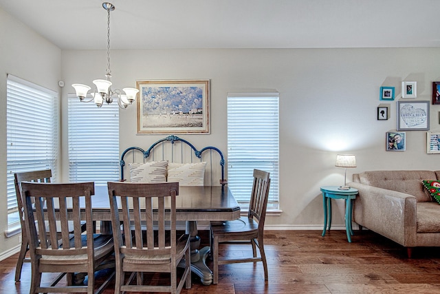 dining room featuring a notable chandelier, wood finished floors, and baseboards