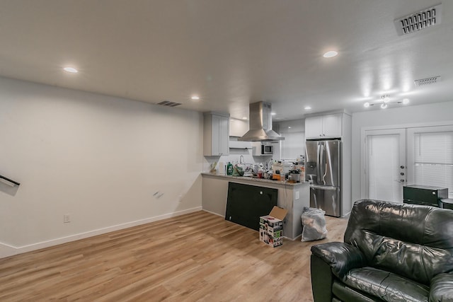 kitchen with french doors, light hardwood / wood-style flooring, stainless steel fridge, white cabinets, and island exhaust hood