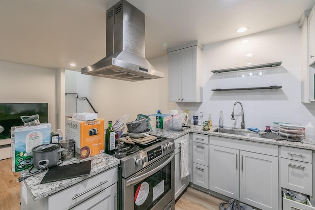 kitchen with light hardwood / wood-style flooring, sink, light stone counters, stainless steel electric stove, and island exhaust hood