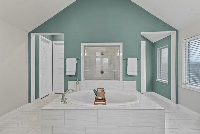 bathroom with lofted ceiling, a garden tub, a shower stall, and baseboards