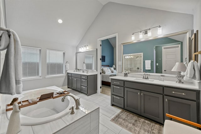 ensuite bathroom featuring ensuite bath, high vaulted ceiling, a bath, and vanity