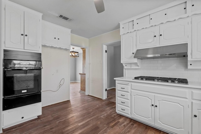 kitchen with light countertops, white cabinets, black oven, and under cabinet range hood