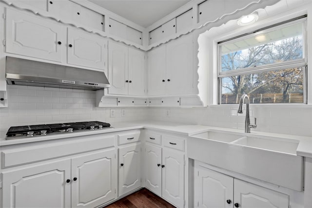 kitchen with white cabinets, under cabinet range hood, stainless steel gas stovetop, and light countertops