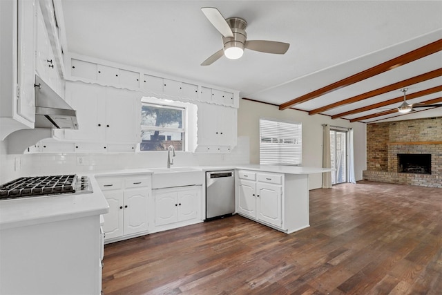 kitchen featuring stainless steel appliances, a peninsula, a sink, open floor plan, and light countertops