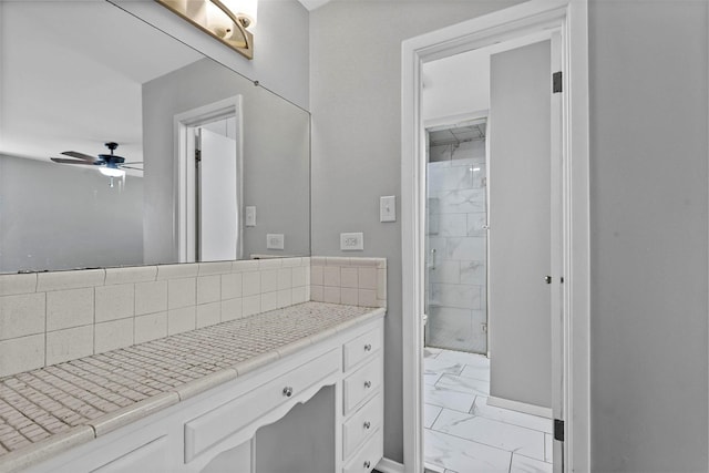 bathroom featuring baseboards, decorative backsplash, a ceiling fan, marble finish floor, and vanity