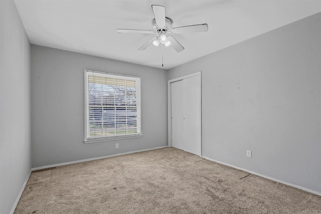 unfurnished room featuring light carpet, baseboards, and a ceiling fan