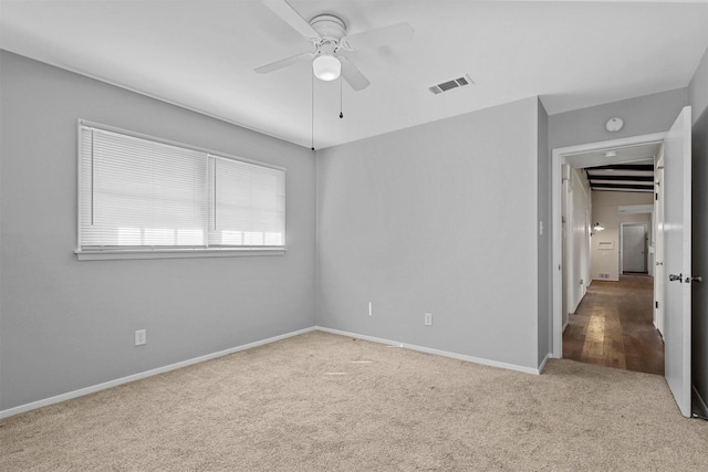 spare room with baseboards, ceiling fan, visible vents, and carpet flooring