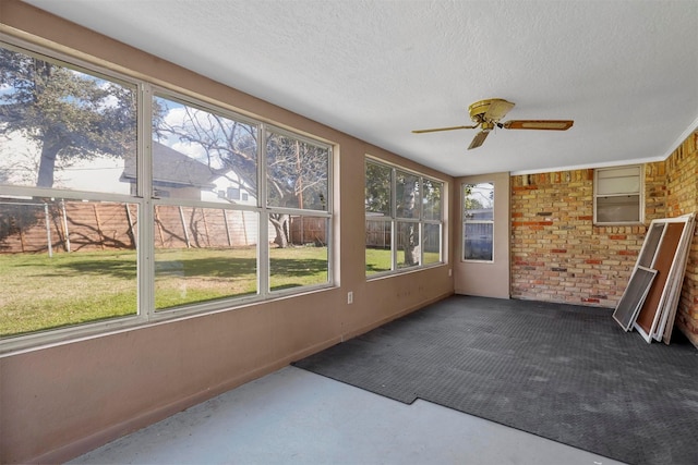 unfurnished sunroom featuring ceiling fan