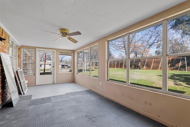 unfurnished sunroom featuring ceiling fan