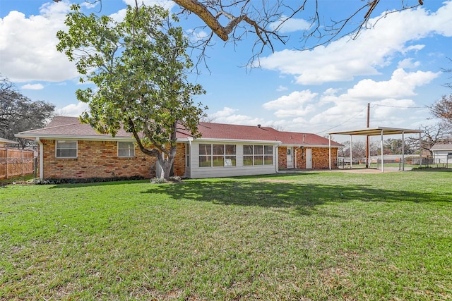 back of property featuring a yard, brick siding, and fence