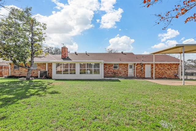 rear view of house with a yard and brick siding