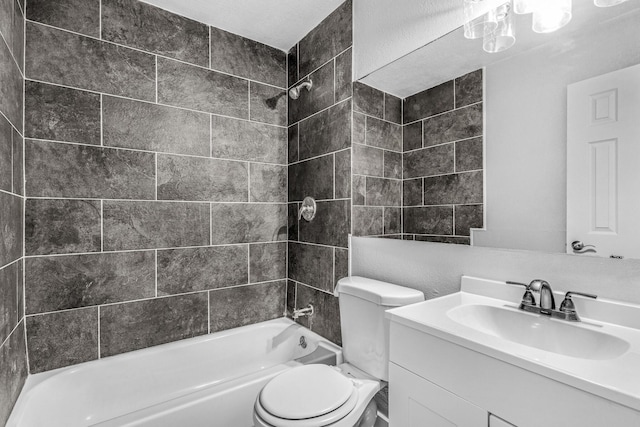 full bathroom featuring tiled shower / bath combo, vanity, and toilet