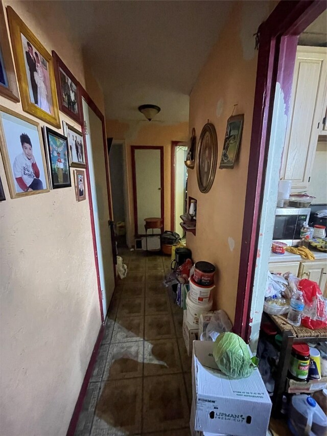 misc room with tile patterned flooring, ceiling fan, and a textured ceiling