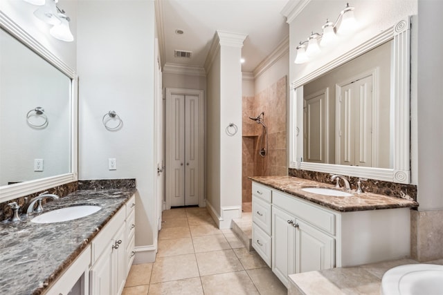 bathroom featuring tile patterned flooring, vanity, crown molding, and tiled shower