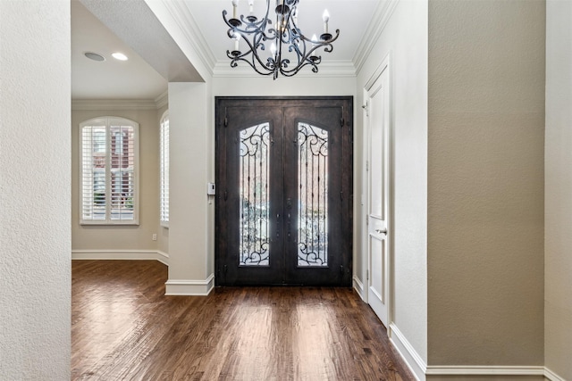 entrance foyer with french doors, crown molding, dark hardwood / wood-style floors, and a notable chandelier