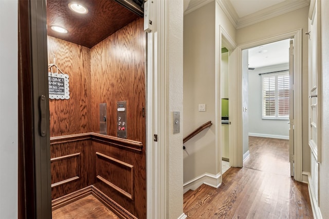 details featuring hardwood / wood-style floors, elevator, and ornamental molding