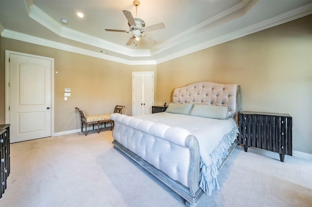 carpeted bedroom with ceiling fan, crown molding, a raised ceiling, and a closet