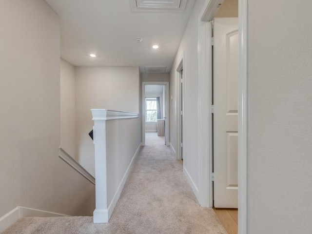 hallway with recessed lighting, an upstairs landing, baseboards, and light carpet