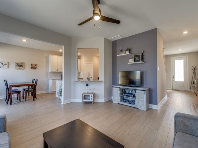 living area featuring recessed lighting, visible vents, baseboards, and light wood-style flooring