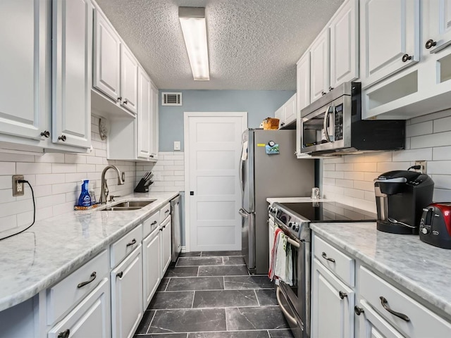 kitchen with white cabinets, stainless steel appliances, and a sink