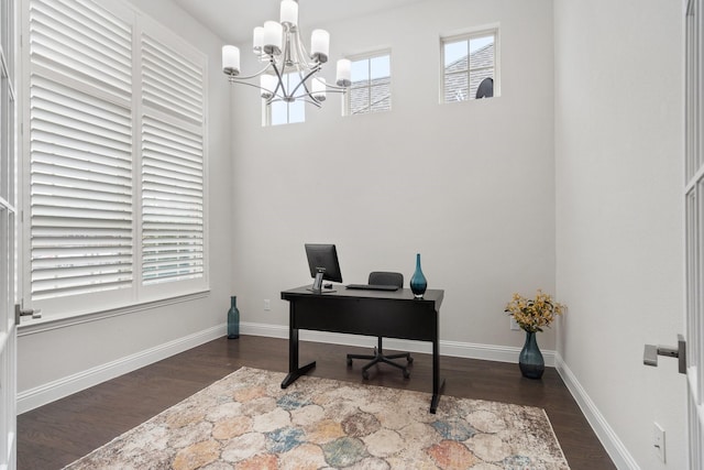 office space featuring a chandelier, wood finished floors, and baseboards