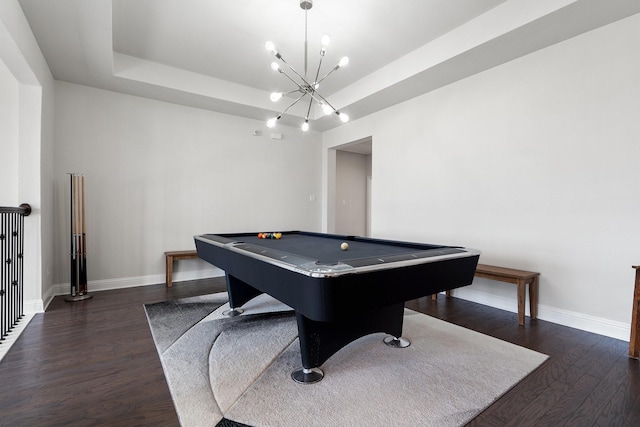 playroom with a tray ceiling, dark wood-style flooring, and baseboards