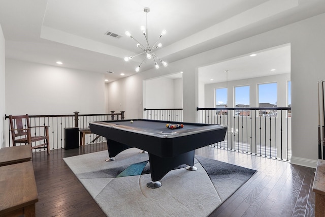 game room with visible vents, dark wood finished floors, a tray ceiling, a notable chandelier, and recessed lighting