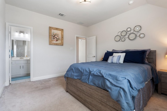 carpeted bedroom featuring lofted ceiling, baseboards, visible vents, and ensuite bathroom