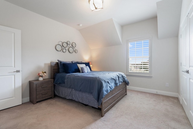 carpeted bedroom with vaulted ceiling and baseboards