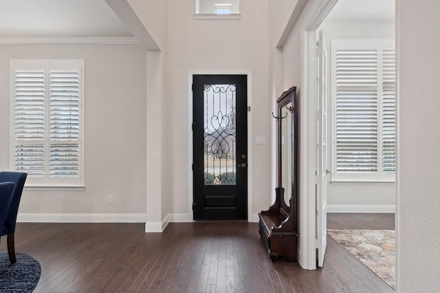 entryway with ornamental molding, dark wood-style flooring, and baseboards