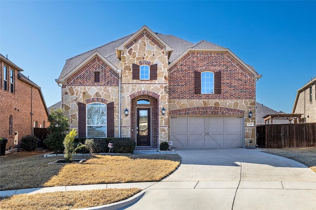 view of front of property featuring driveway, a shingled roof, stone siding, an attached garage, and brick siding