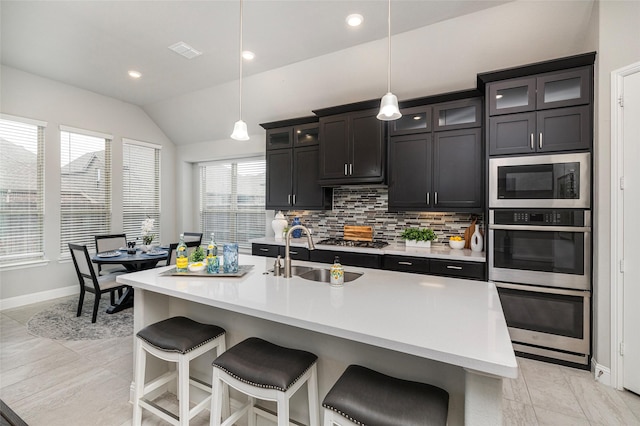 kitchen with backsplash, a sink, and light countertops