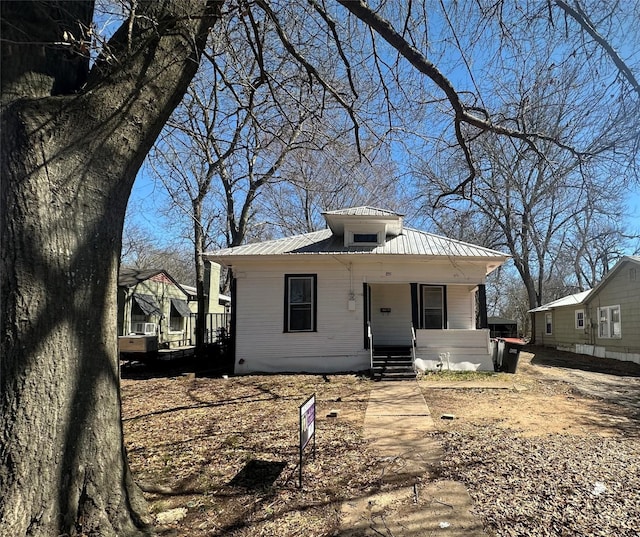 bungalow-style house featuring covered porch and metal roof