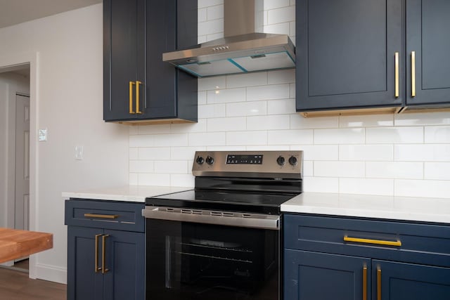 kitchen with blue cabinetry, range with electric stovetop, tasteful backsplash, and wall chimney range hood