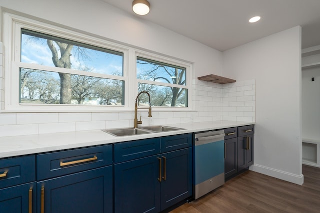 kitchen featuring tasteful backsplash, stainless steel dishwasher, blue cabinets, dark hardwood / wood-style flooring, and sink