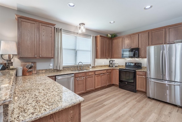2745 Sunlight Dr, Little Elm, TX 75068 - kitchen featuring sink, black appliances, light stone countertops, and light hardwood / wood-style flooring