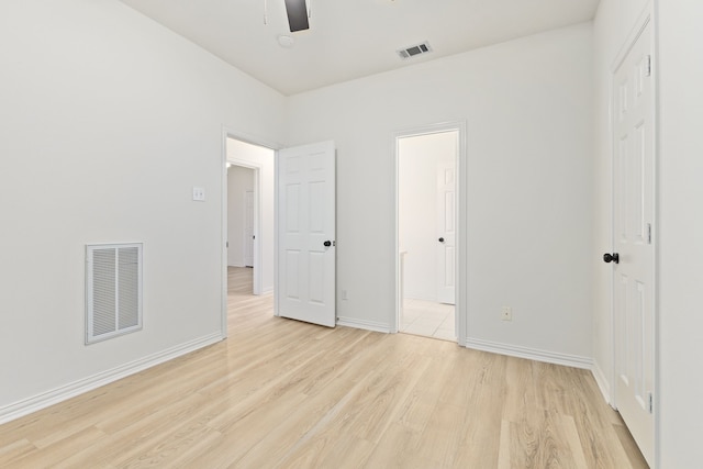 unfurnished bedroom featuring ensuite bathroom, ceiling fan, and light hardwood / wood-style flooring