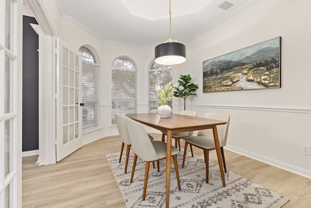 dining space featuring ornamental molding and light hardwood / wood-style floors