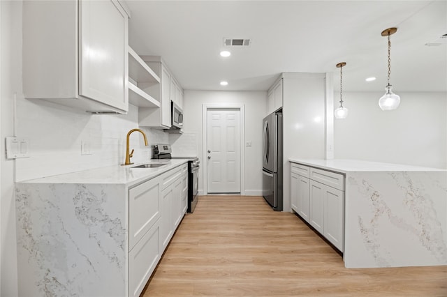 kitchen featuring visible vents, hanging light fixtures, a sink, open shelves, and stainless steel appliances