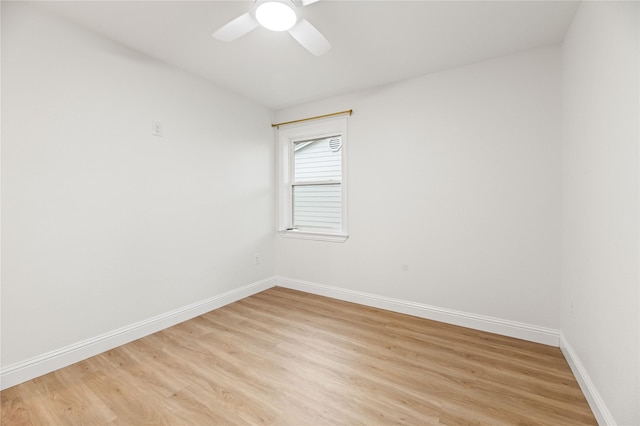 empty room featuring a ceiling fan, baseboards, and light wood-type flooring