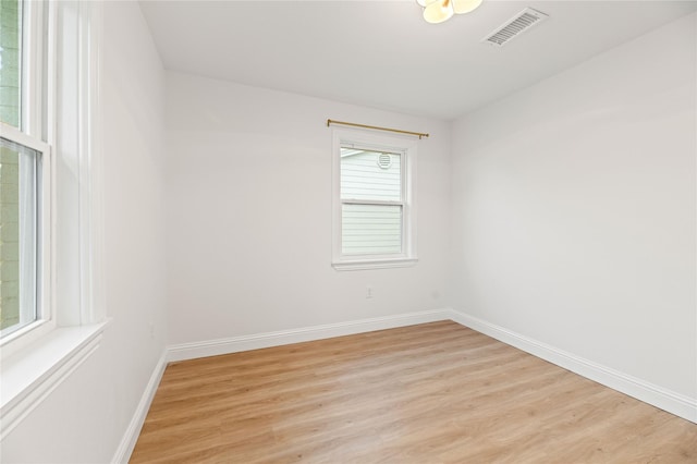 unfurnished room featuring baseboards, visible vents, and light wood finished floors