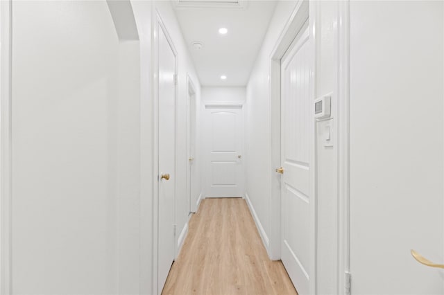 hallway with baseboards, recessed lighting, and light wood-type flooring