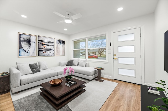 living area featuring a ceiling fan, baseboards, light wood-style floors, and recessed lighting